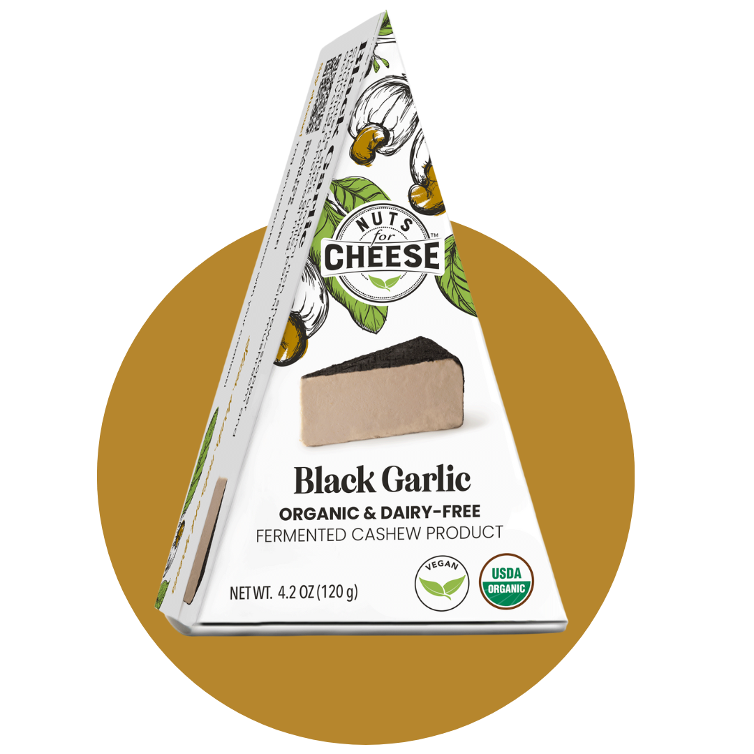 Nuts For Cheese™ Emballage de fromage à l'ail noir fermenté, biologique et sans produits laitiers, sur fond de cercle doré.