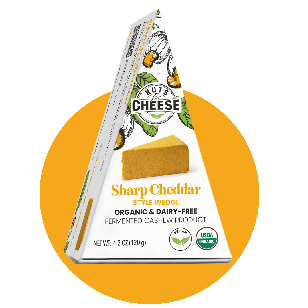 Nuts For Cheese™ Emballage de fromage cheddar fort fermenté biologique et sans produits laitiers sur un fond circulaire jaune.