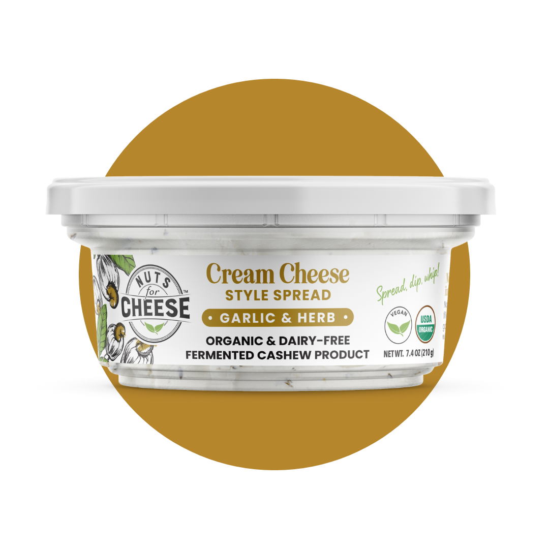 Nuts For Cream Cheese™ Emballage de fromage frais fermenté à l'ail et aux fines herbes, biologique et sans produits laitiers, sur fond de cercle doré